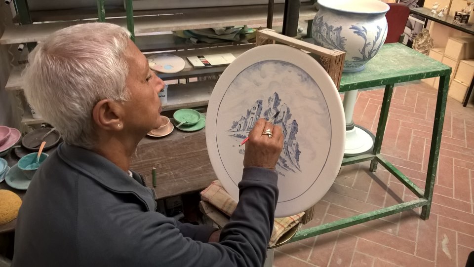 Clara Biagi dipinge un piatto in stile Bianco Blu o Antico Savona. Tradizione. Ceramiche Pierluca. Albisola, Savona.